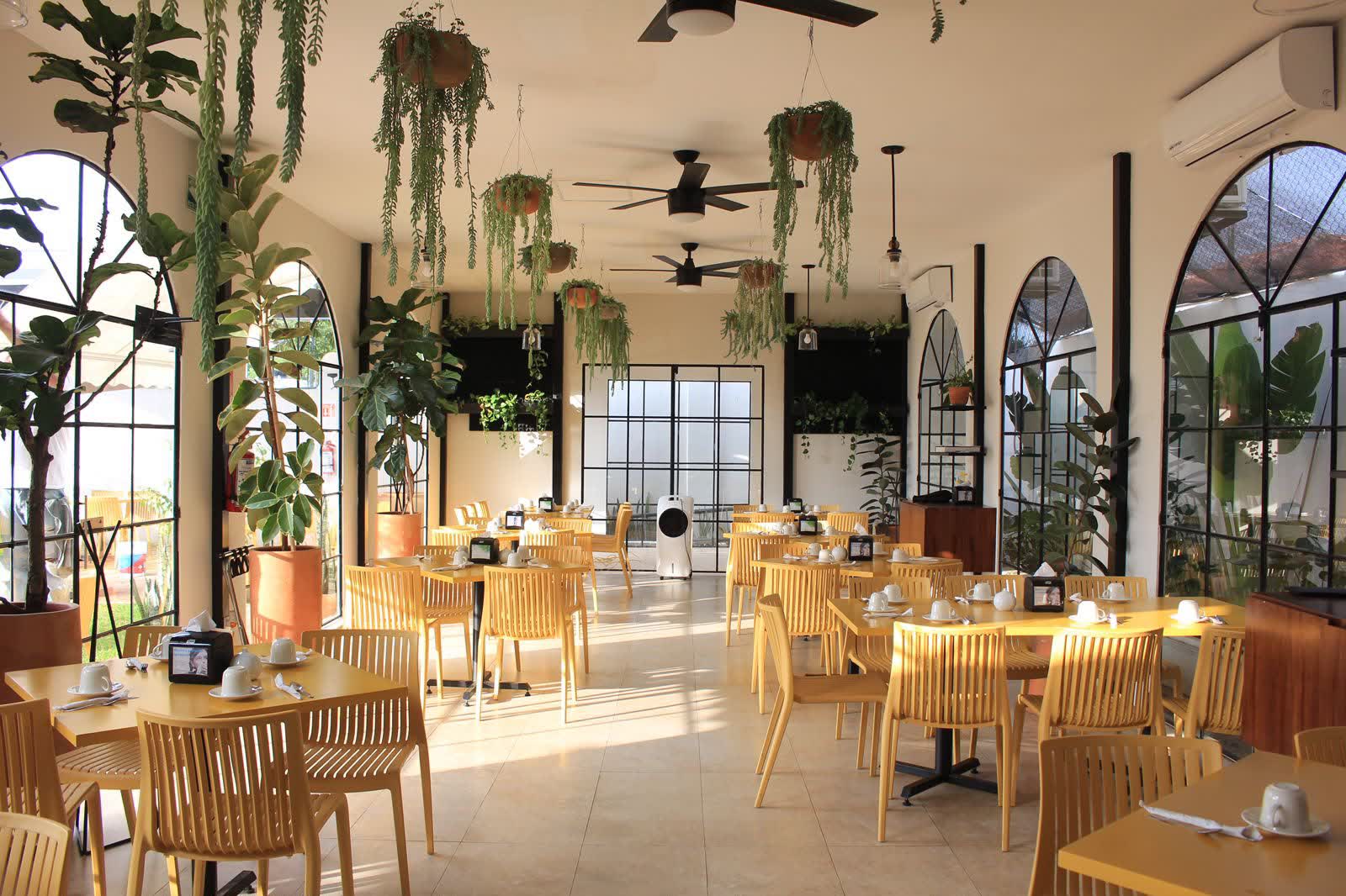 Comedor de Sibarita Campestre con ventanales en arco y plantas colgantes